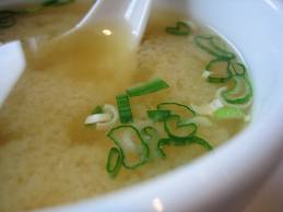 Closeup of a bowl of miso soup with sliced scallions